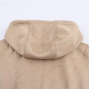 Détail d'une veste à capuche en daim kaki montrant les coutures et la texture mate