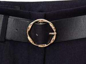 Détail d'une ceinture en cuir noir avec boucle dorée sur un short bleu marine cintré