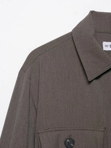 Détail du col de chemise marron foncé avec surpiqûres et fermeture à bouton en résine