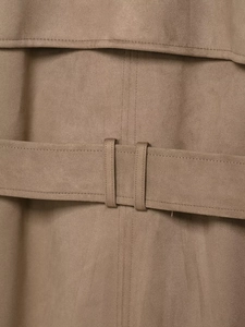 Detailed macro view of khaki faux suede trench coat featuring a belt and stitching