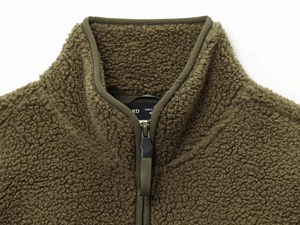 Detailed close-up of olive green teddy fleece collar with zipper and size label