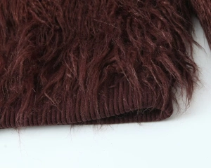 Detail of dark brown faux fur texture with ribbed knit hem on the sleeve and garment