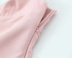 Close-up detail of high-quality invisible zipper on a pink short dress fabric