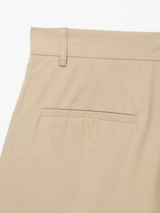 Detailed macro view of the waistband and welt pocket on beige twill trousers