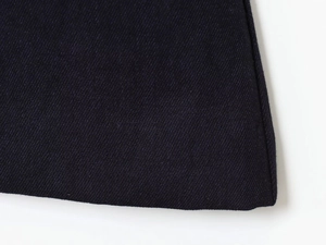 Détail de la texture en sergé bleu marine et coutures précises sur un ensemble blazer