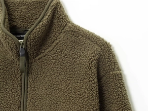 Close-up of olive green fleece jacket neck with half-zip and brand label detail
