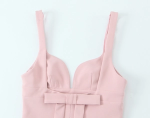 Close-up of pink sleeveless mini dress featuring V-neckline and decorative front bow detail