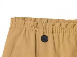 Dettaglio di pantaloncini in twill kaki con elastico in vita e bottone nero singolo