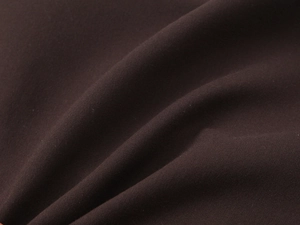 Détail en gros plan d'un tissu tissé marron foncé montrant une texture et un éclat doux