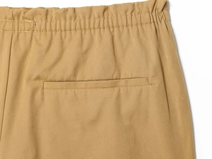 Dettaglio della vita elasticizzata e della tasca posteriore dei pantaloni in cotone kaki