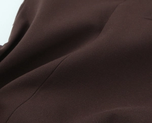 Vue macro détaillée de la texture du tissu tissé marron foncé pour une robe de femme