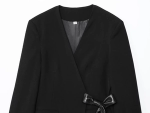 Close-up of black wrap blazer featuring a stylish faux leather bow detail and size S tag