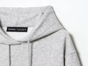 Detailaufnahme des Hoodie-Halslabels mit Größenangaben und feiner Stoffstruktur