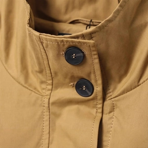Giacca trench corta da donna color kaki con collo alto e bottoni neri in dettaglio