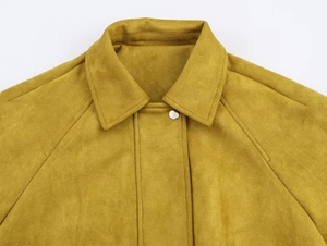 Détail du col d'un blouson aviateur en daim moutarde avec bouton en métal argenté