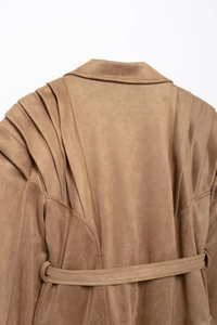 Detail of camel suede jacket featuring unique layered pleats on shoulder and back