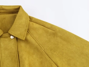 Détail du blouson aviateur en daim moutarde montrant le col et le bouton-pression argenté