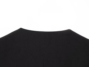 Detailed close-up of the smooth black fabric texture and collar stitching of a blazer