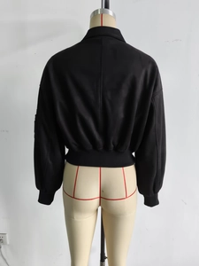 Detail der schwarzen Fliegerjacke mit Umlegekragen und Rippstricksaum an einer Schaufensterpuppe