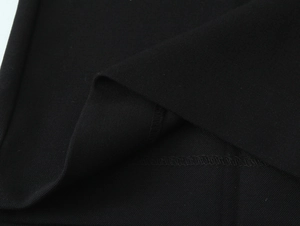 Dettaglio della cucitura sull'orlo di un blazer nero con rifiniture precise e pulite