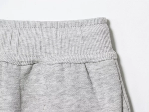 Detail des hellgrauen elastischen Rippstrickbundes einer Jogginghose mit sauberer Naht