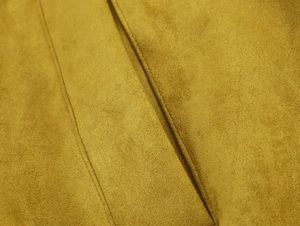 Détail macro de la texture en daim jaune moutarde et des coutures de haute qualité