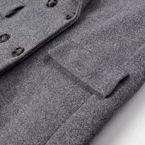 Détail d'un manteau en laine gris foncé avec boutons en résine et poche à rabat