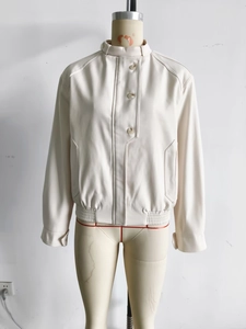 Detail of cream faux leather jacket showing stand collar and three-button closure