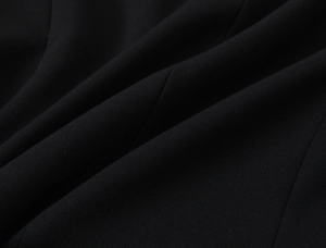 Dettaglio ravvicinato del tessuto pettinato nero per un completo elegante da donna