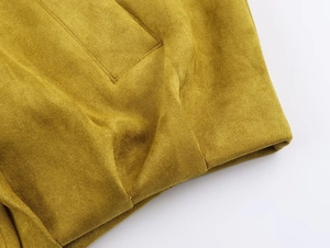 Détail de la veste aviateur en suédine jaune moutarde montrant les coutures de la poche