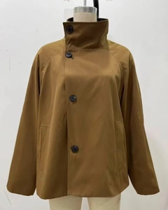 Detail view of double-sided short trench jacket with asymmetrical buttons and stand collar