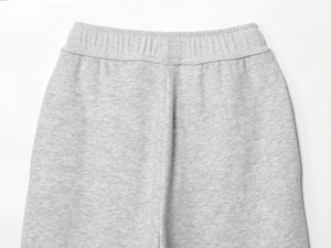 Detailaufnahme des elastischen Bunds der hellgrauen Jogginghose mit feiner Naht