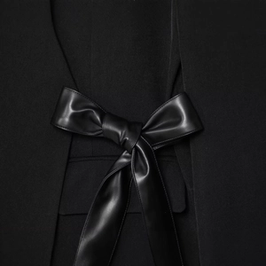 Fashionable black wrap blazer jacket featuring a premium faux leather bow accent