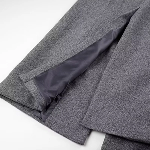 Détail de l'ourlet d'un manteau en laine grise avec doublure et coutures soignées