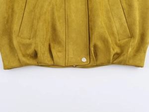 Détail de la veste aviateur en suédine moutarde montrant le tissu et le bouton argenté