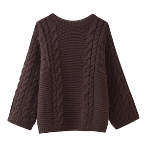 Close-up of chocolate brown cable-knit sweater featuring thick woven texture and ribbed cuffs