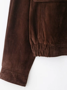 Gros plan d'un blouson aviateur en daim marron avec ourlet élastique et poignets côtelés