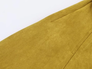 Gros plan sur la texture en suédine jaune moutarde et les détails de couture renforcés