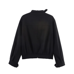 Detail view of the back of a black minimalist jacket with stand collar and ribbed hem