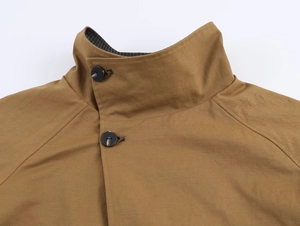 Detail of tan jacket high stand collar with striped lining and black buttons