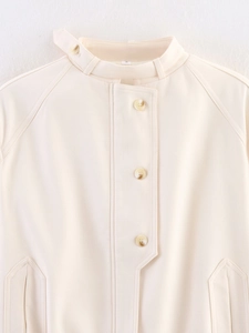 Close-up of cream buttoned jacket with stand collar and marble-textured buttons