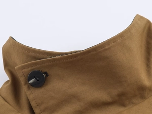 Close-up of khaki cotton trench coat collar featuring black resin button and check lining