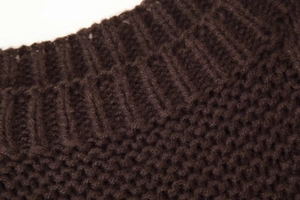 Detail of dark brown cable knit sweater showing ribbing texture on the neckline