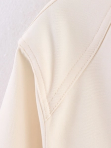 Detail of shoulder stitching on a beige jacket with durable twill fabric texture