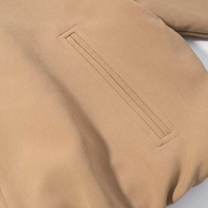 Detail der khakifarbenen Jacke mit hochwertiger Paspeltasche und Twill-Textur-Gewebe
