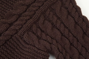 Close-up detail of coffee brown cable knit texture on a long sleeve pullover sweater