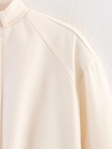 Detail of beige jacket collar with raglan sleeve design and double-needle stitching