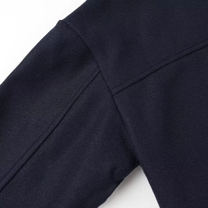 Détail du tissu en laine bleu marine montrant les coutures et la texture de qualité