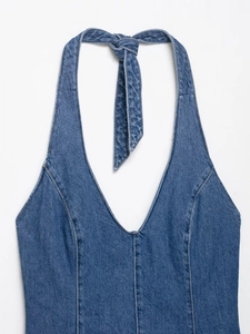 Detail of blue denim halter neck dress featuring deep V-neckline and tie-back design