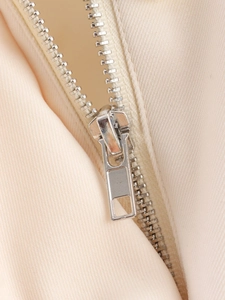Macro detail of high-quality silver metal zipper on beige twill jacket fabric